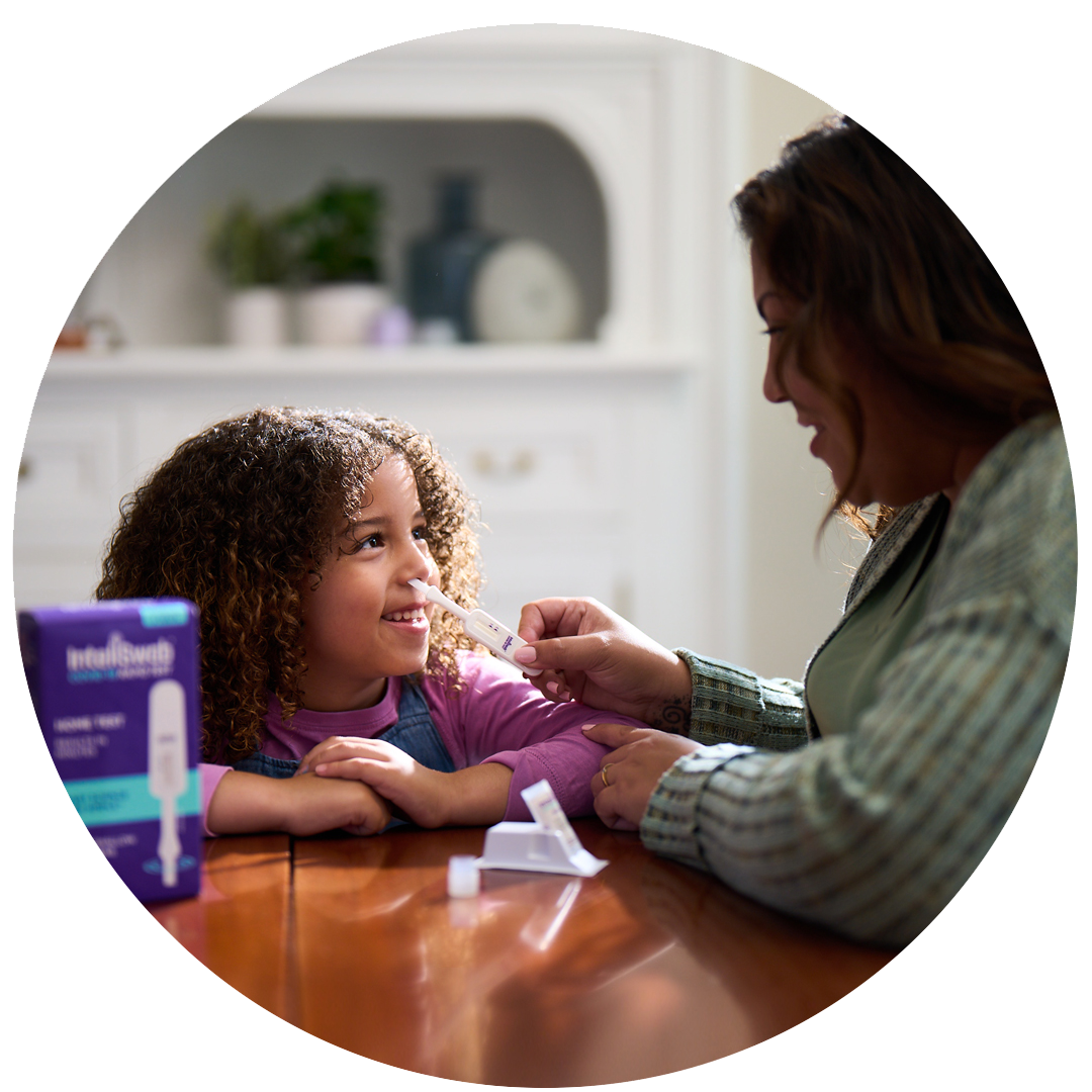 A woman swabs a young girl's nose.